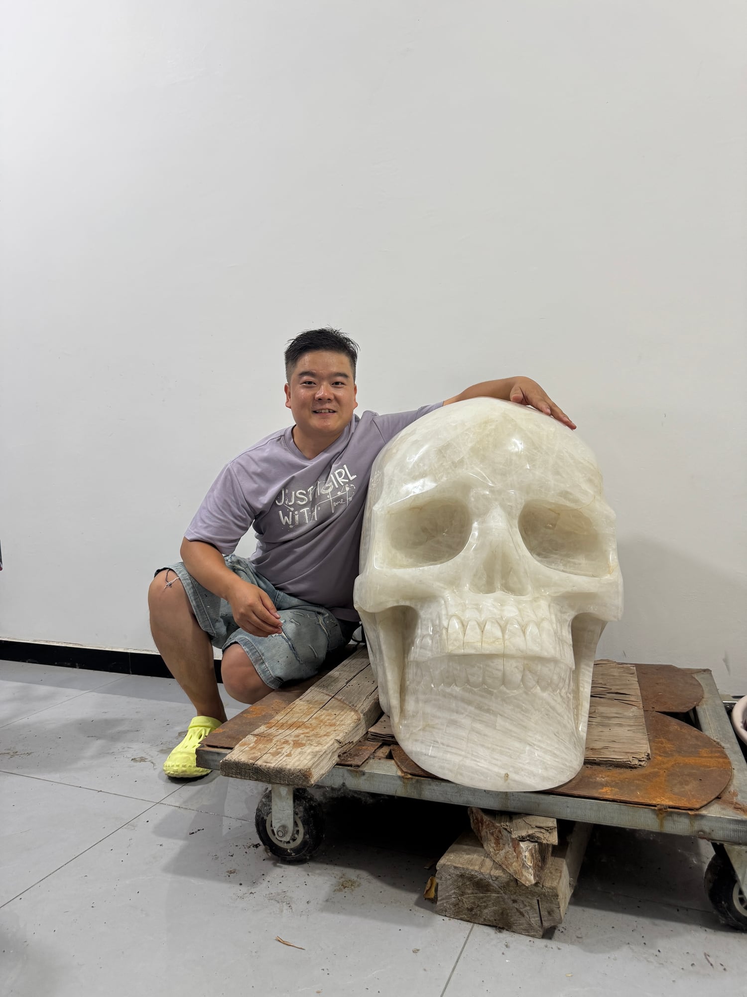 Monumental crystal skull carved in the CRYSKULL workshop, shown with a person for scale